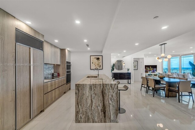 living room with light tile patterned floors, a wall of windows, and a wealth of natural light