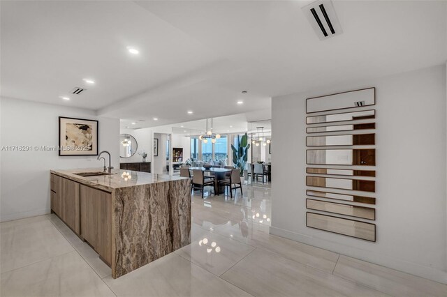 1500 Ocean Dr Unit 1003, Miami Beach, FL 33139 - kitchen featuring light stone countertops, modern cabinets, visible vents, and a sink