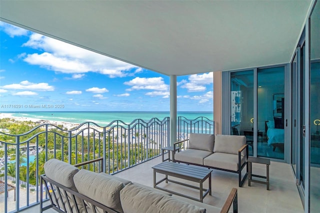 balcony featuring a view of the beach, a water view, and outdoor lounge area