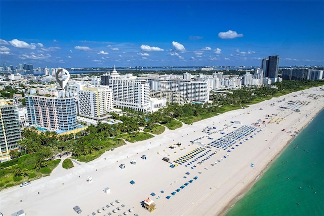 aerial view featuring a water view, a view of city, and a beach view