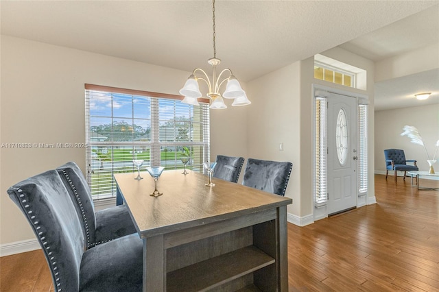 dining room featuring dark hardwood / wood-style floors and an inviting chandelier