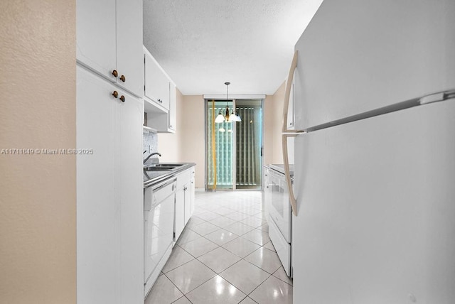 kitchen with hanging light fixtures, a wall of windows, white cabinets, white appliances, and light tile patterned floors