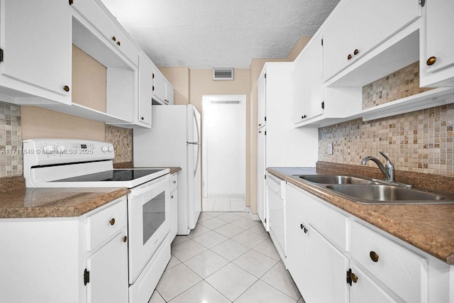 kitchen with white appliances, backsplash, sink, light tile patterned flooring, and white cabinetry