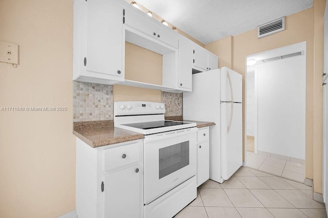 kitchen with backsplash, white cabinetry, light tile patterned floors, and white appliances