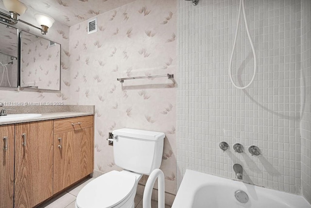 full bathroom featuring tile patterned floors, vanity, toilet, and tiled shower / bath