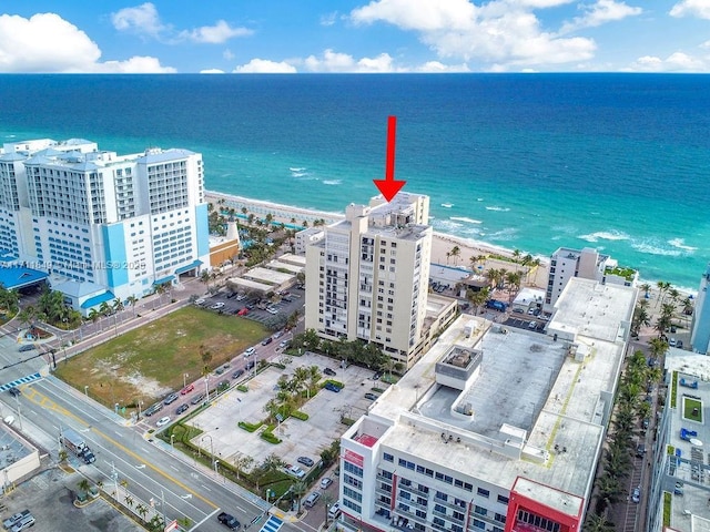 bird's eye view with a water view and a beach view