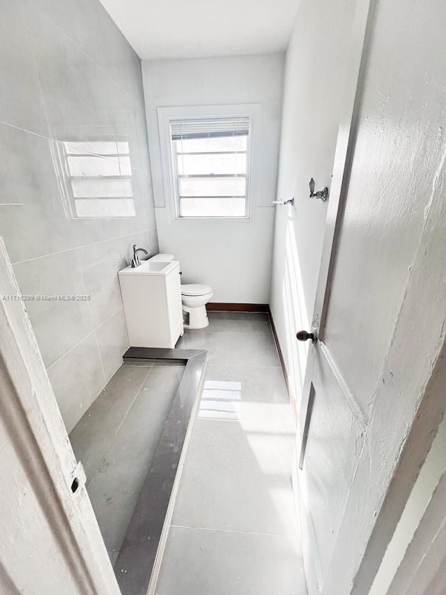 bathroom with toilet, sink, and concrete floors