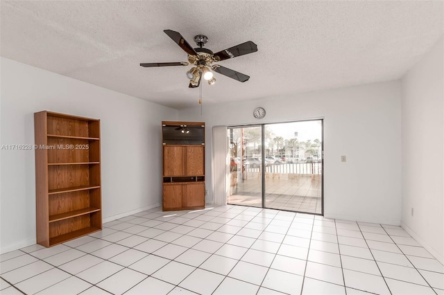 tiled empty room featuring ceiling fan and a textured ceiling