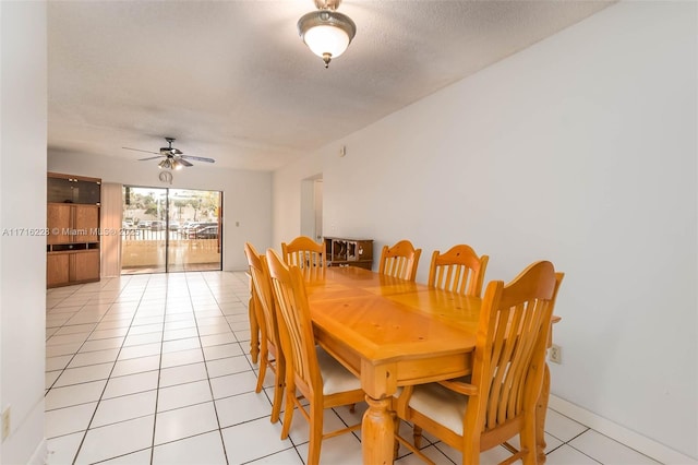 tiled dining space with a textured ceiling and ceiling fan