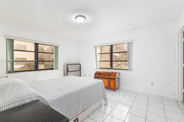 bedroom with a textured ceiling and light tile patterned flooring