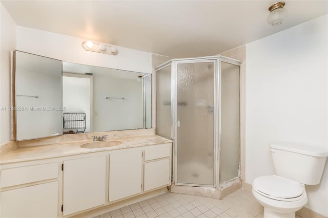 bathroom featuring tile patterned floors, vanity, toilet, and a shower with door