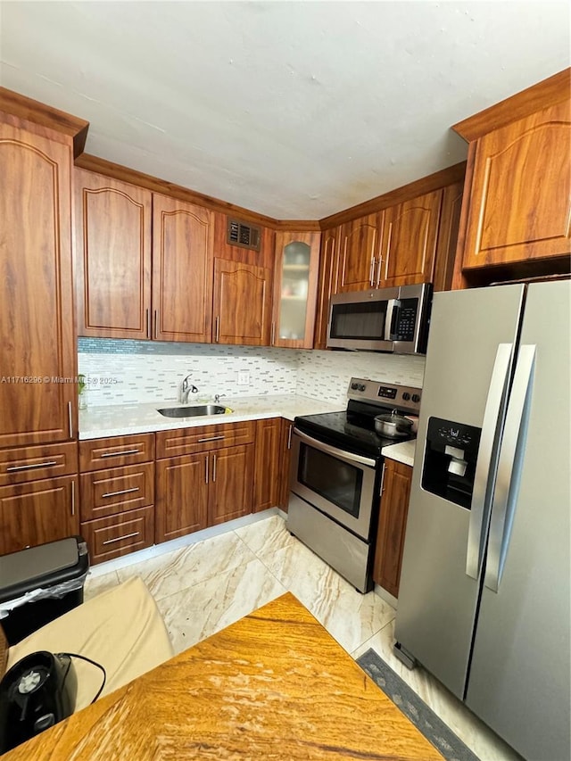 kitchen with decorative backsplash, appliances with stainless steel finishes, and sink