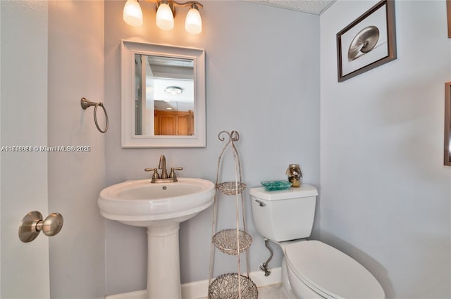 bathroom featuring a textured ceiling and toilet