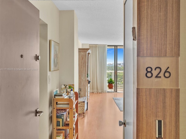 corridor with expansive windows and wood-type flooring