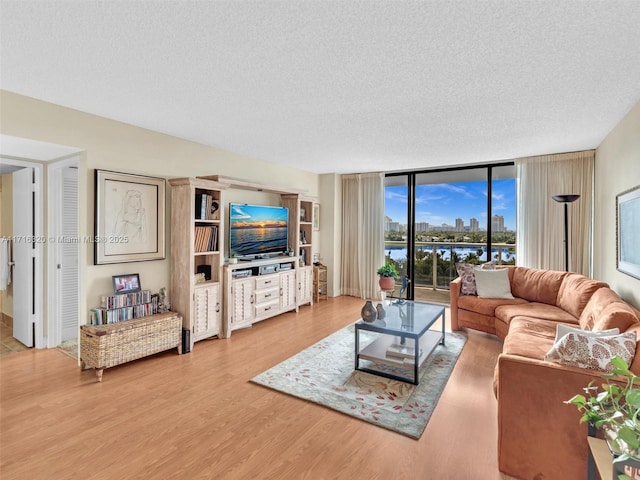 living room featuring floor to ceiling windows, wood-type flooring, and a textured ceiling