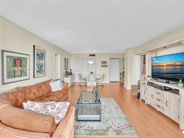 living room featuring light hardwood / wood-style floors and a textured ceiling