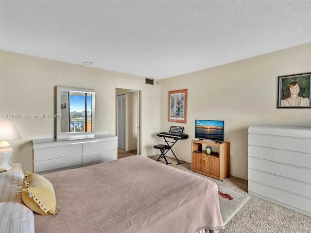 bedroom featuring a textured ceiling and light carpet