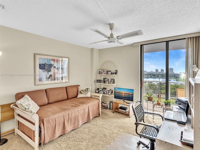 carpeted office space featuring ceiling fan, a wall of windows, and a textured ceiling