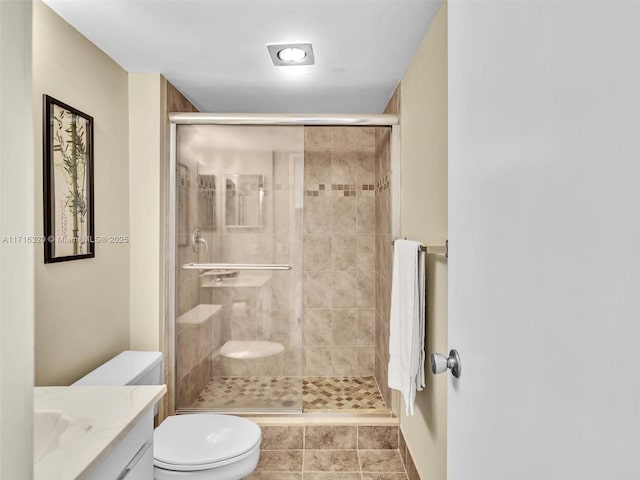 bathroom featuring vanity, an enclosed shower, and toilet