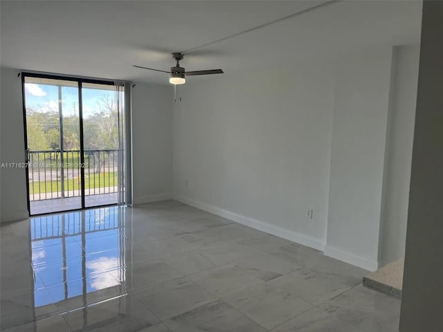 spare room with ceiling fan and floor to ceiling windows