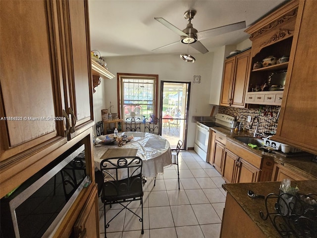 kitchen featuring ceiling fan, lofted ceiling, electric stove, decorative backsplash, and light tile patterned flooring