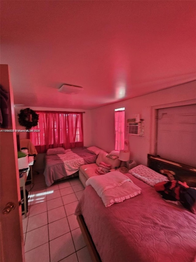 bedroom featuring light tile patterned floors and a wall unit AC