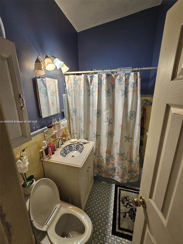 bathroom with sink, tile walls, and toilet