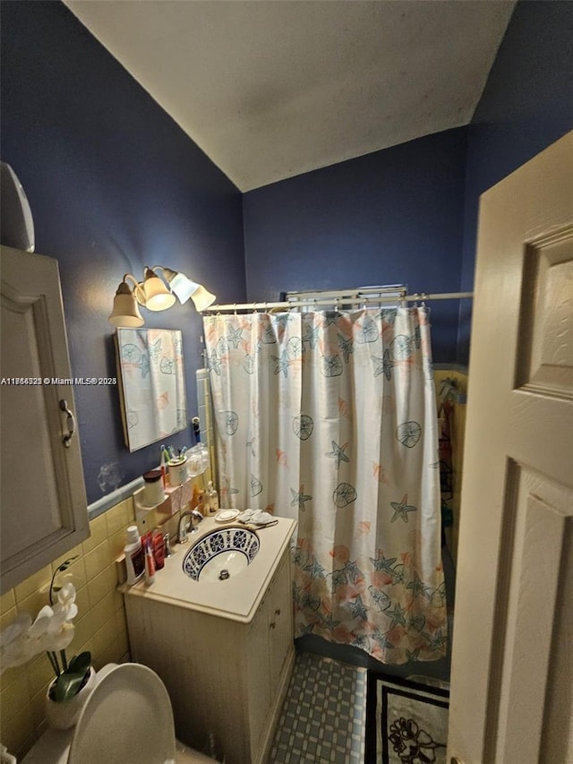 bathroom with sink and tile walls