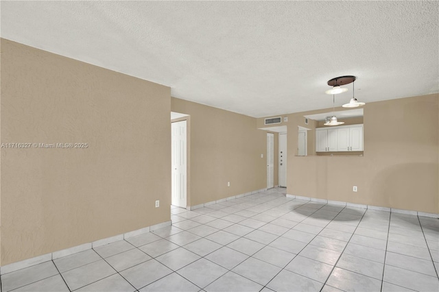 unfurnished room with light tile patterned floors and a textured ceiling