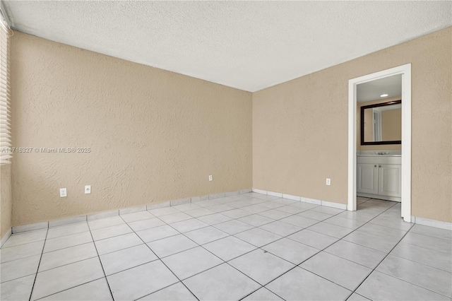 tiled empty room with a textured ceiling