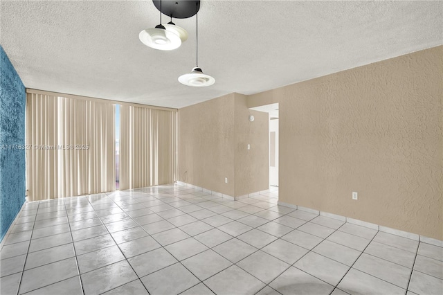 unfurnished room featuring light tile patterned flooring and a textured ceiling