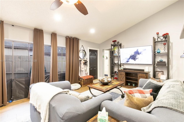 living room with ceiling fan, light hardwood / wood-style flooring, and lofted ceiling