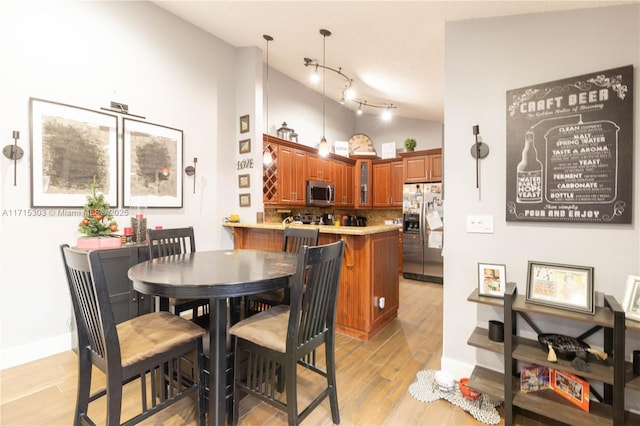 dining room featuring light hardwood / wood-style floors and lofted ceiling