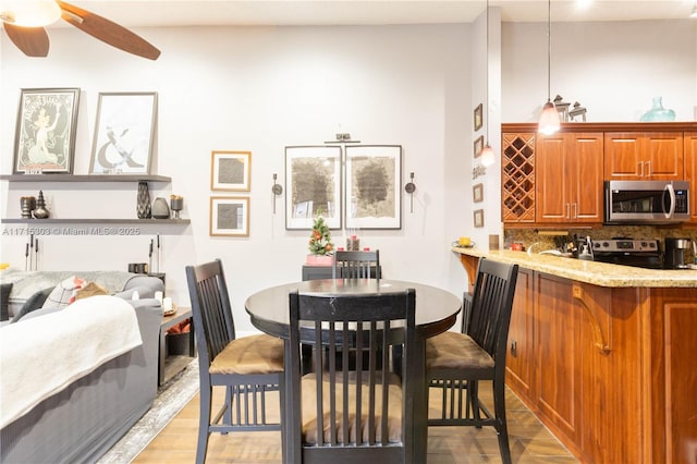 dining room with light hardwood / wood-style floors and ceiling fan