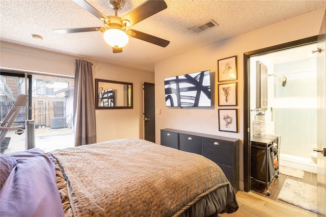 bedroom with ceiling fan, ensuite bathroom, and a textured ceiling