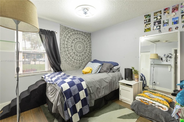 bedroom featuring dark hardwood / wood-style flooring and a textured ceiling