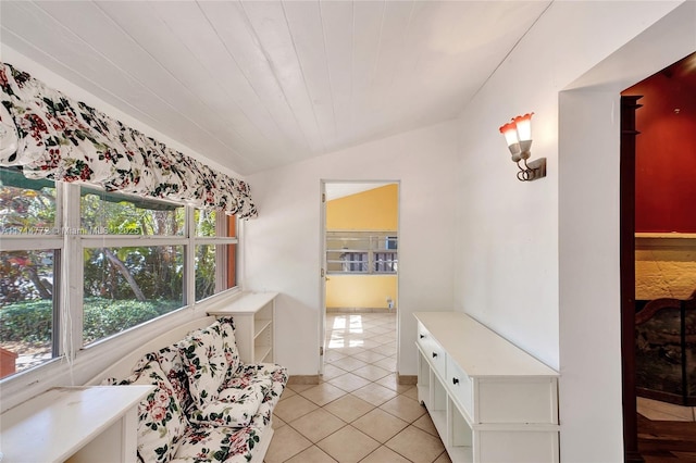 corridor featuring light tile patterned floors, wood ceiling, and vaulted ceiling