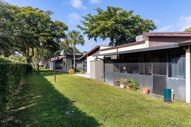 view of yard with central AC unit and a sunroom