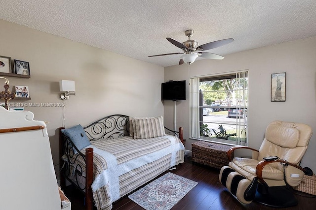 bedroom featuring ceiling fan, a textured ceiling, and dark wood-type flooring