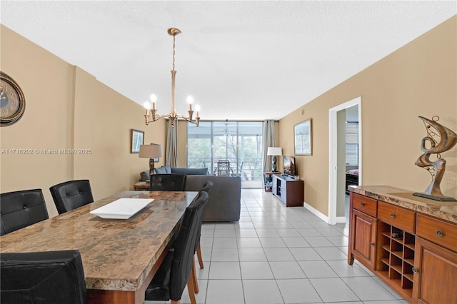 dining room featuring a wall of windows, a textured ceiling, light tile patterned floors, and a chandelier