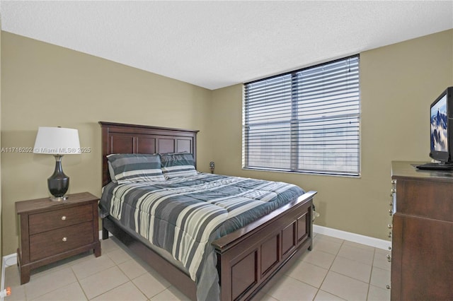 bedroom featuring light tile patterned floors and a textured ceiling