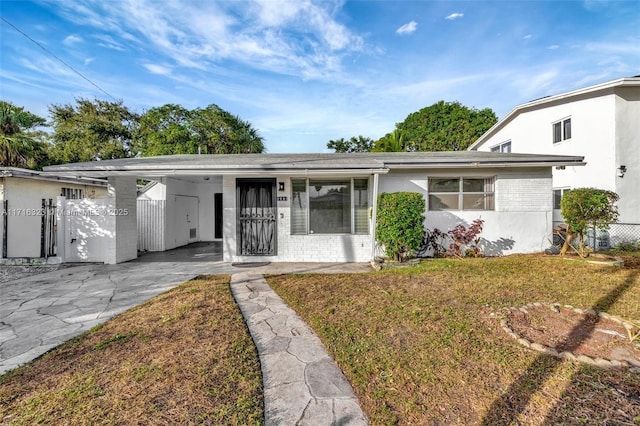 ranch-style home with a front lawn and a carport