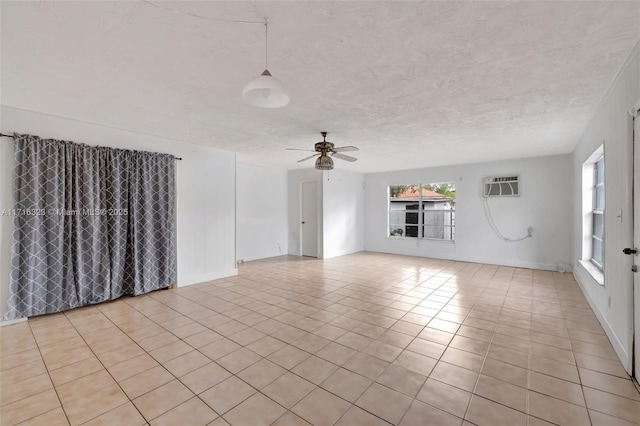 interior space with a wall mounted air conditioner, light tile patterned floors, a textured ceiling, and ceiling fan