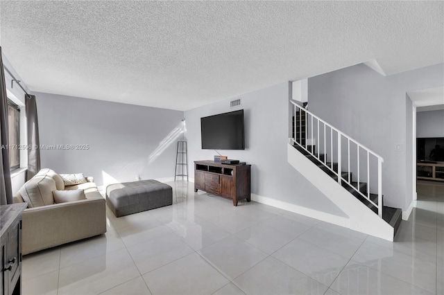 tiled living room featuring a textured ceiling