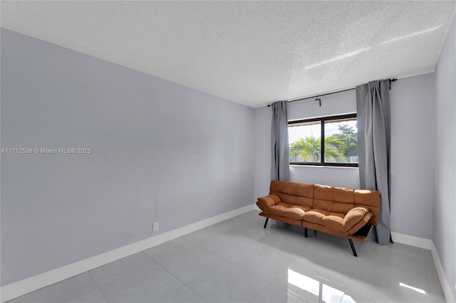 living area with light tile patterned floors and a textured ceiling