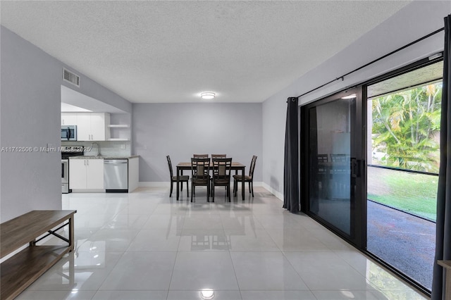 tiled dining area with a textured ceiling