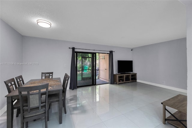 tiled dining space featuring a textured ceiling