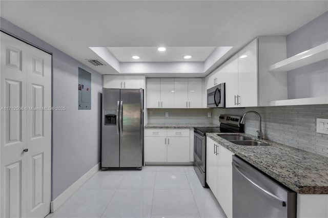 kitchen with a raised ceiling, sink, white cabinets, and stainless steel appliances