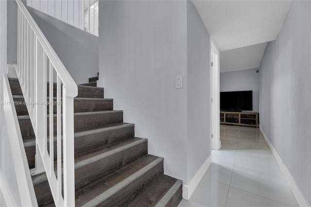 stairway featuring tile patterned flooring