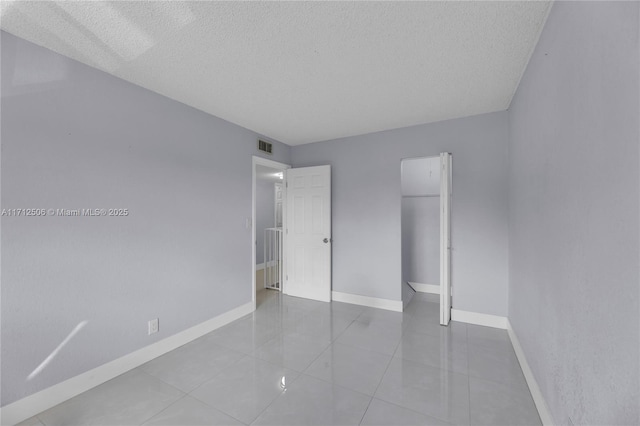 unfurnished bedroom featuring light tile patterned floors and a textured ceiling